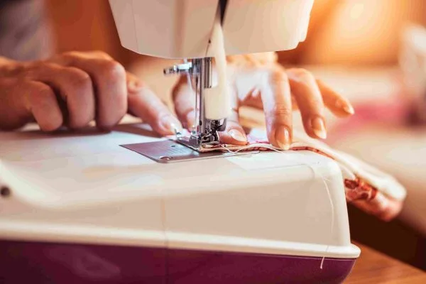 Close up of hands using a sewing machine