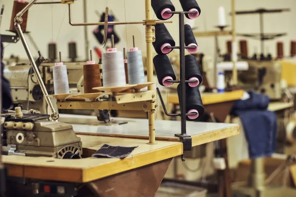 Industrial sewing machines and spools of thread in an apparel factory